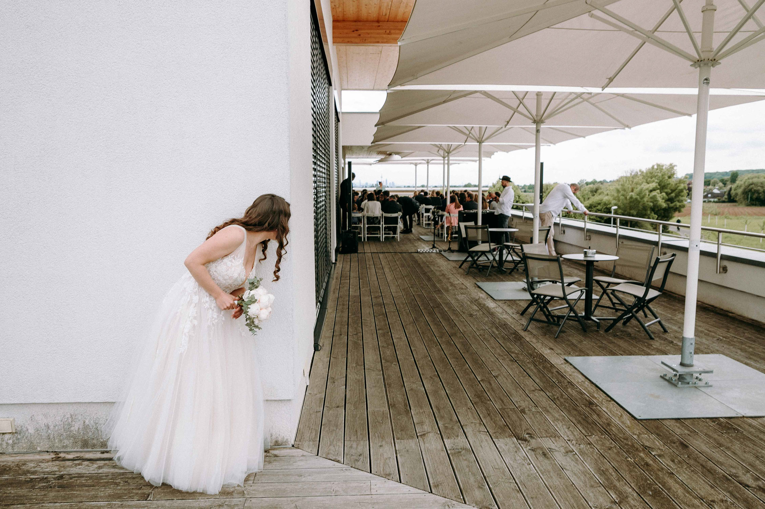 Die Braut schaut neugierig um die Ecke vor ihrem grossen Moment bei der freien Trauung