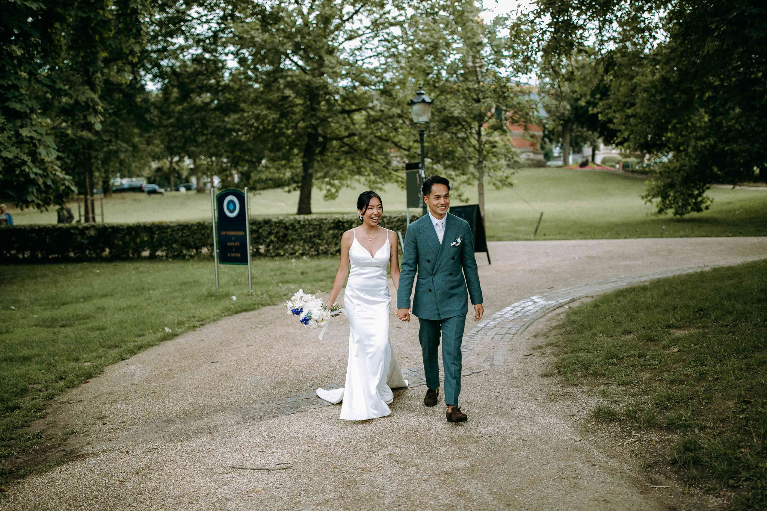 Fröhlicher Empfang bei der Hochzeitslocation Golfhaus Restaurant Bad Homburg. Das Paar läuft zur Location und strahlt.