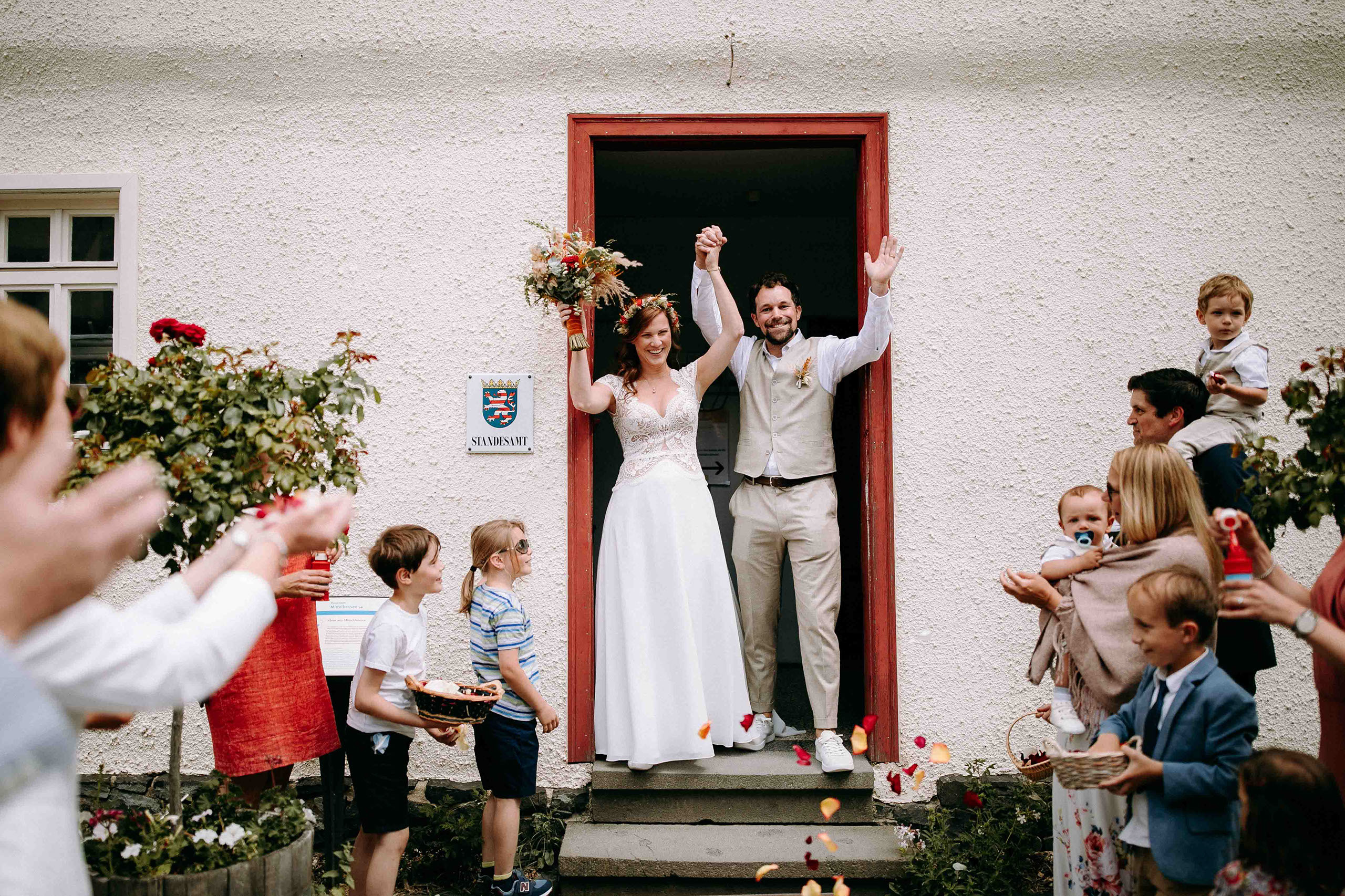 Auszug des Brautpaars mit Rosenblättern im Freilichtmuseum Hessenpark – festliche Atmosphäre für Hochzeitsreportagen.