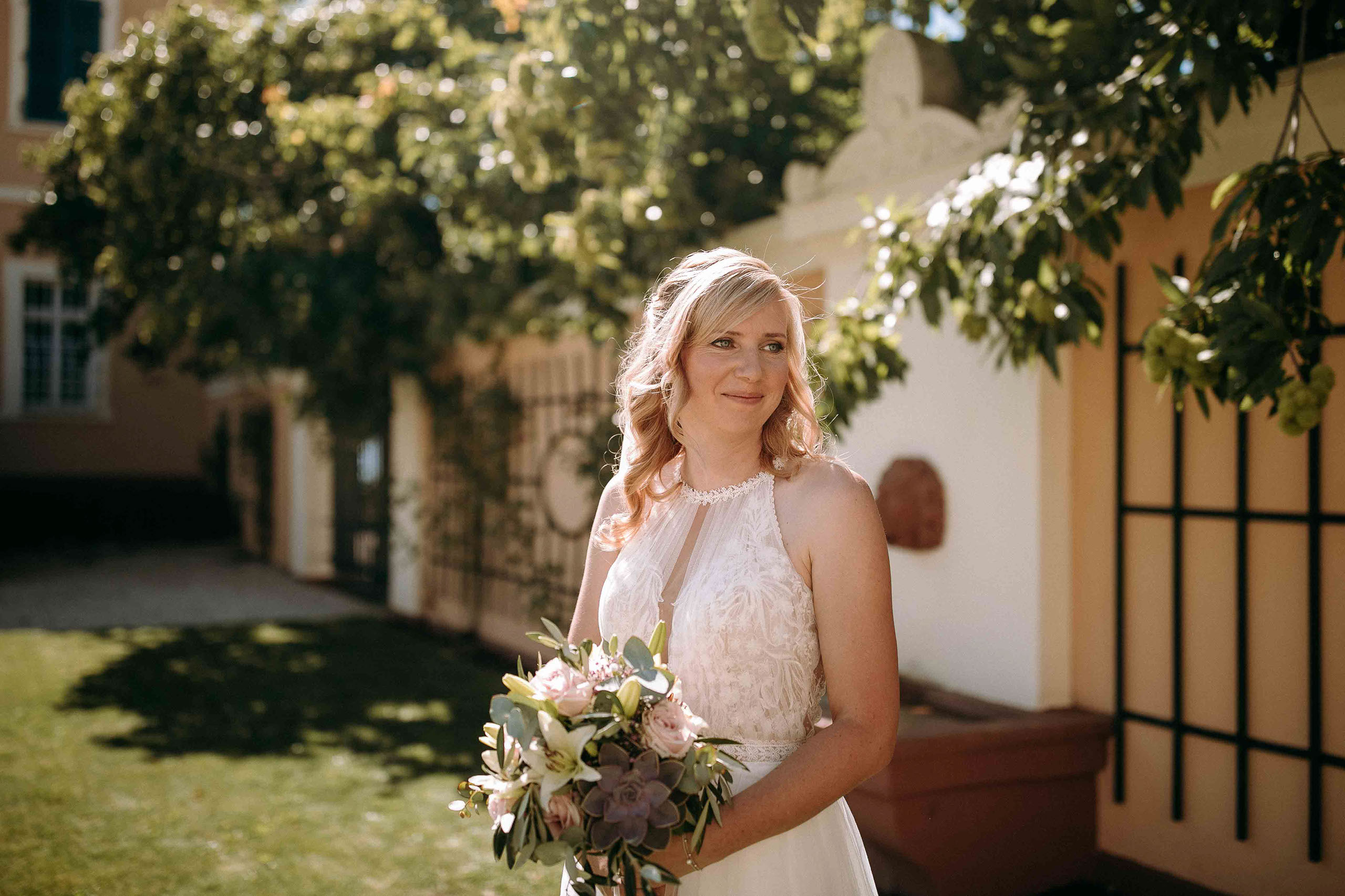 Strahlende Braut mit Brautstrauß im Schlossgarten von Schloss Johannisberg – romantisches Hochzeitsportrait