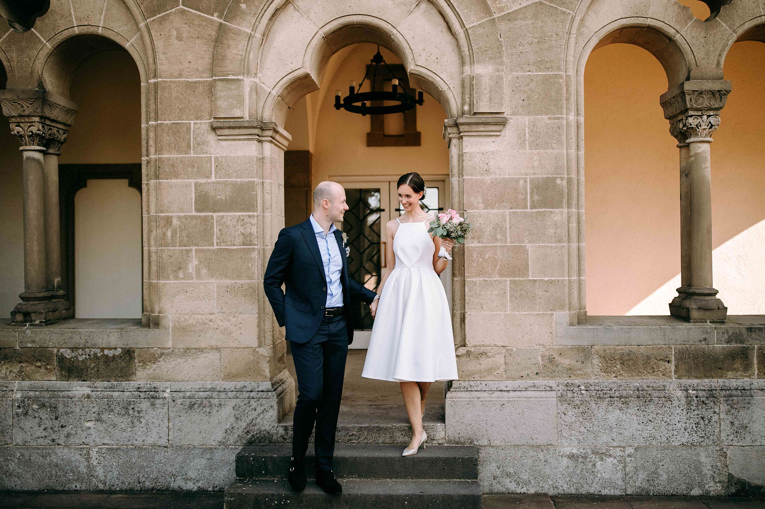 Hochzeitslocation Schloss Bad Homburg: Brautpaar verlässt gemeinsam den Weissen Saal Hand in Hand