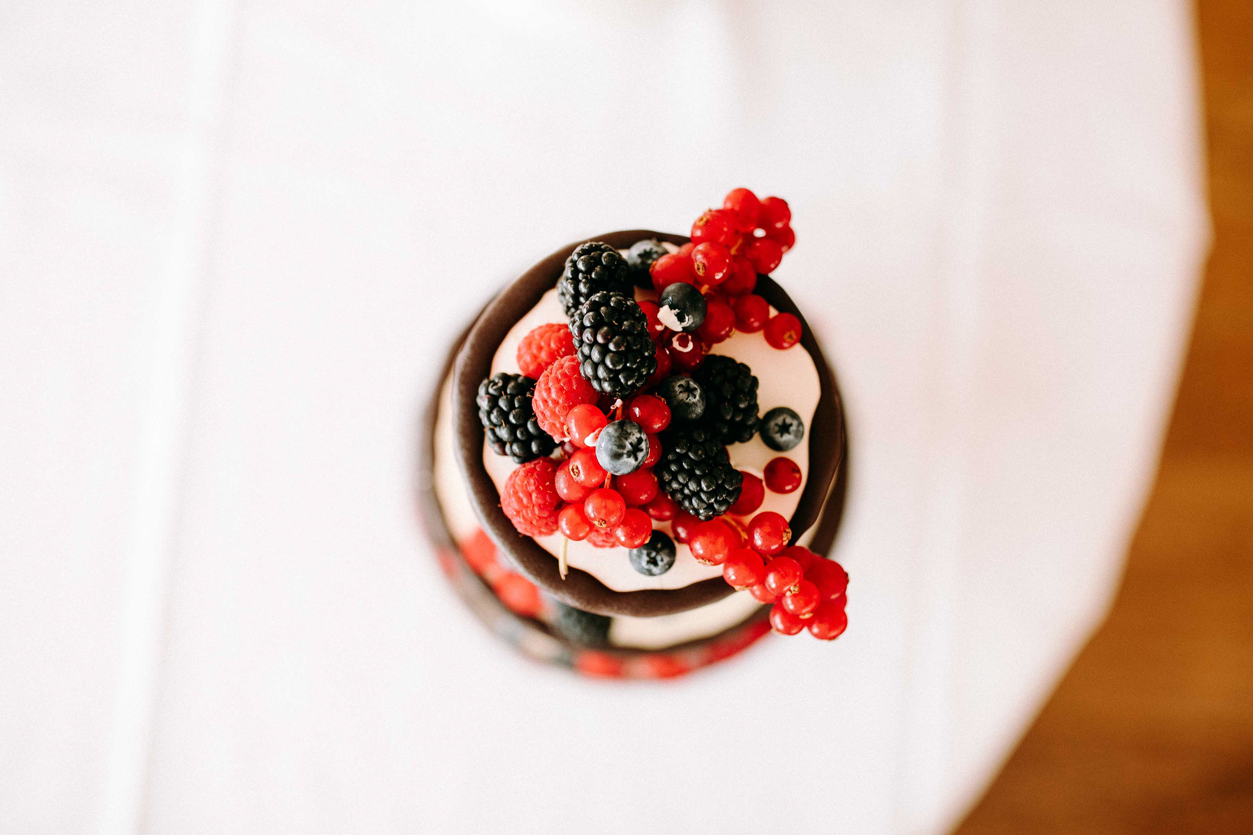 Detailaufnahme einer Hochzeitstorte mit frischen Beeren auf Schloss Johannisberg – Hochzeitsfotograf Rheingau