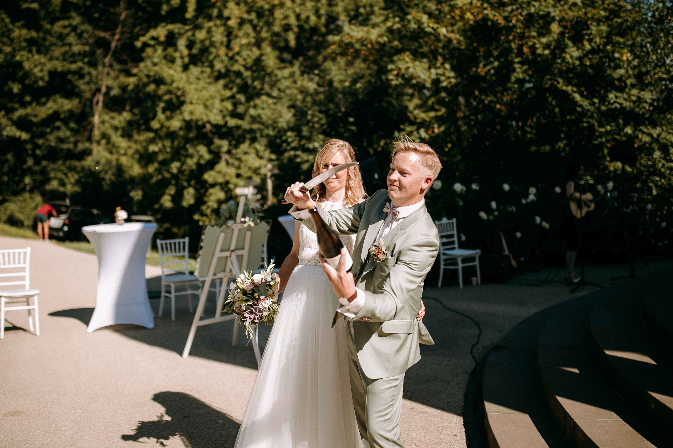 Bräutigam sabriert Sektflasche bei der Hochzeit an der Hochzeitslocation Am Niederwald im Rheingau.