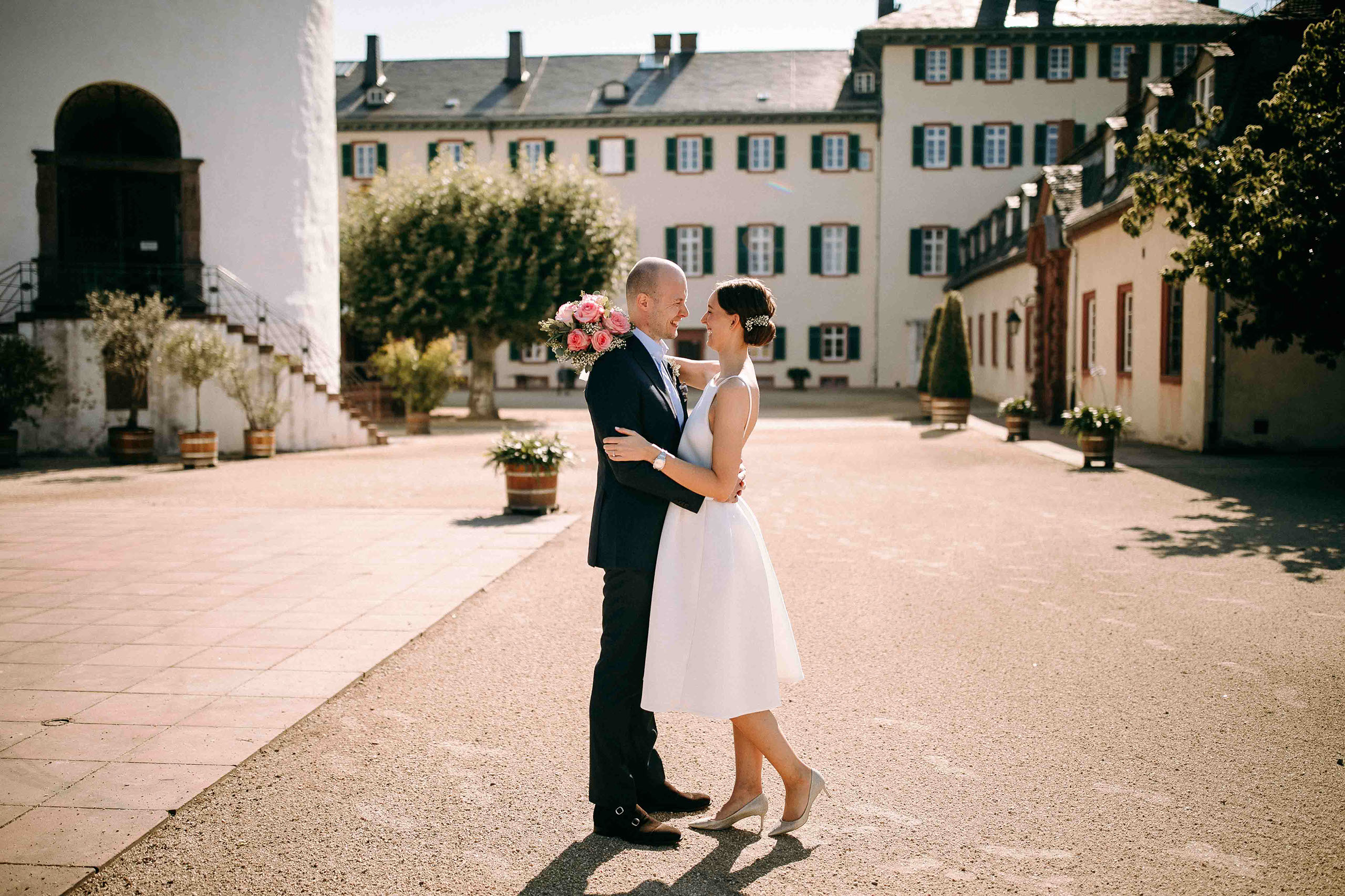 Umarmung des Brautpaares im Schlosshof – Hochzeitslocation Schloss Bad Homburg