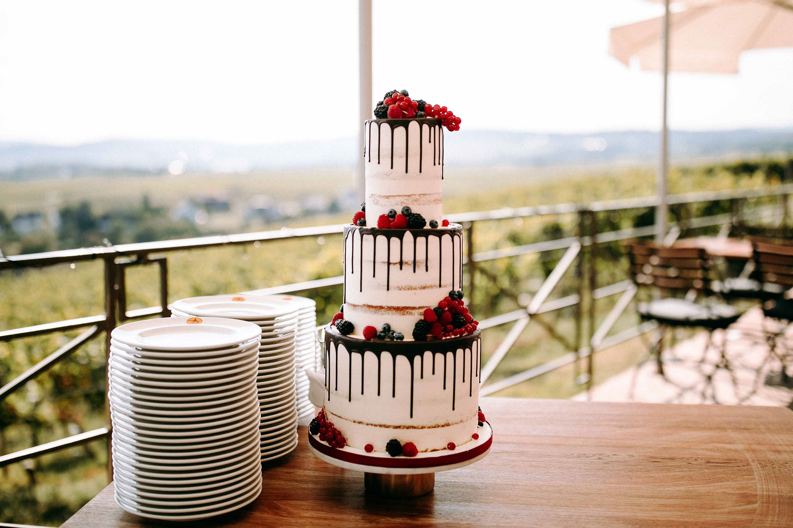 Hochzeitstorte mit Beeren im Außenbereich von Schloss Johannisberg, perfektes Motiv für Hochzeitsfotograf Rheingau
