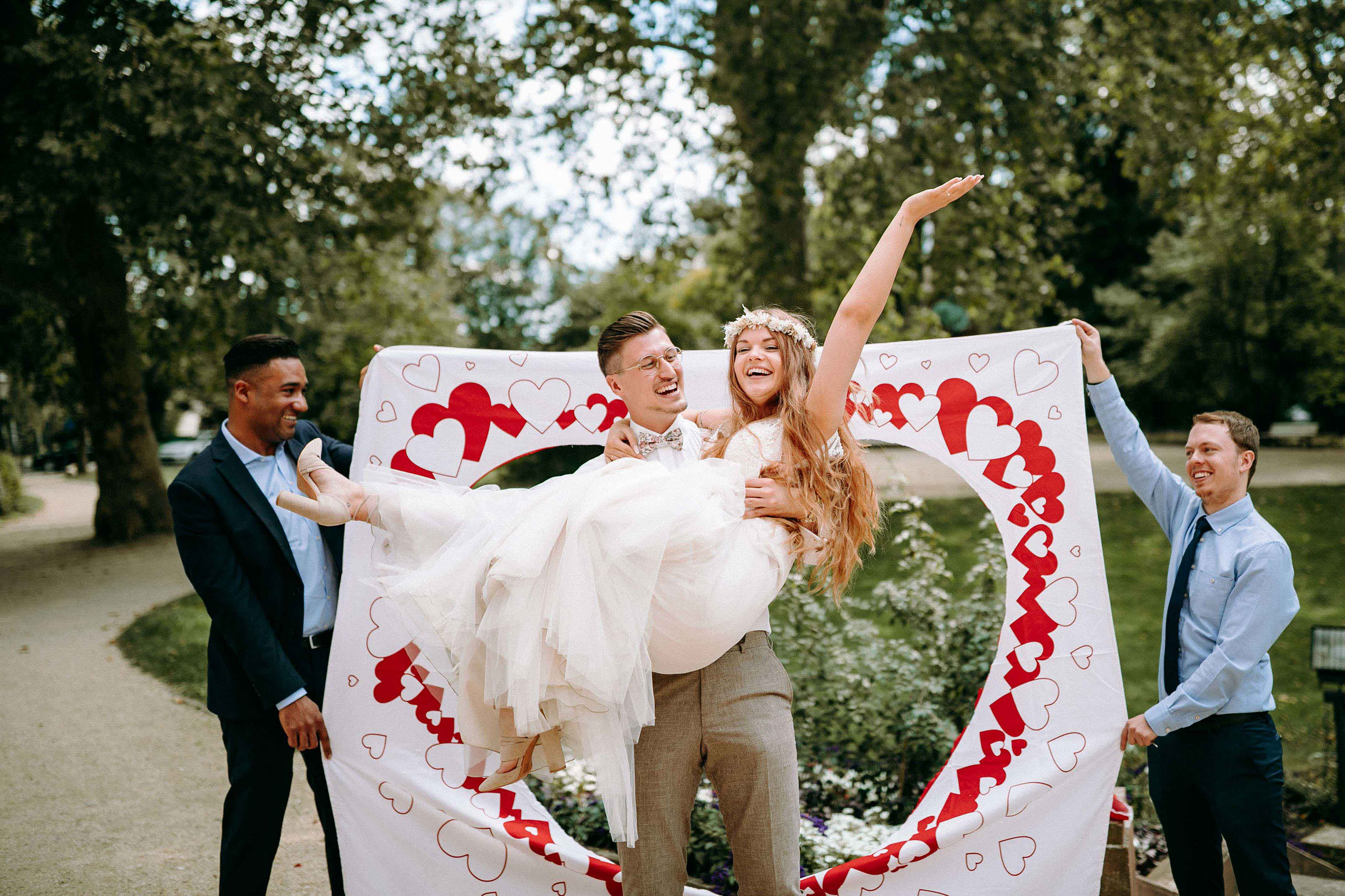 Brautpaar beim Ausschneiden eines Herzens aus einem Laken – Hochzeitsspiel in der Orangerie Bad Homburg.
