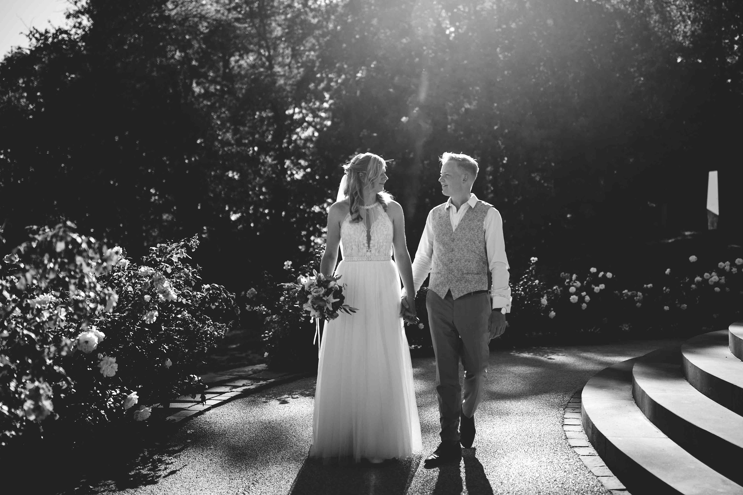 Braut und Bräutigam gehen Hand in Hand am Niederwaldtempel entlang – Hochzeitsfotografie Rheingau.