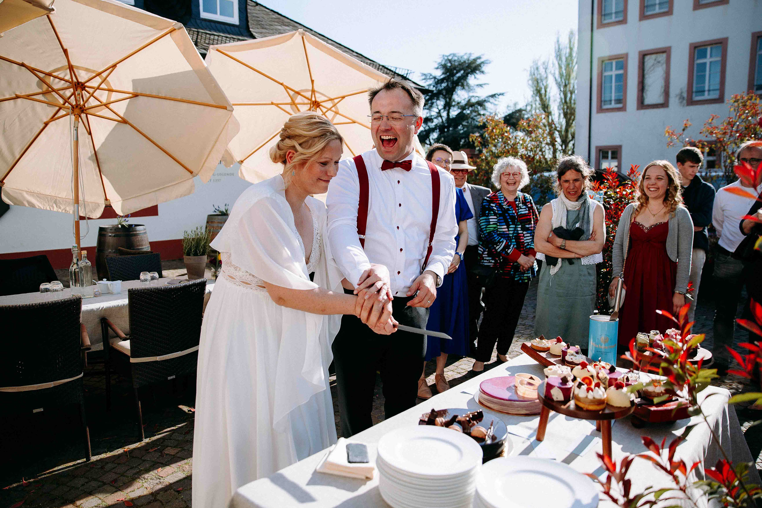 Das Brautpaar schneidet gemeinsam die Hochzeitstorte an – emotionaler Moment in der Hochzeitslocation Schloss Reinhartshausen im Rheingau, einge