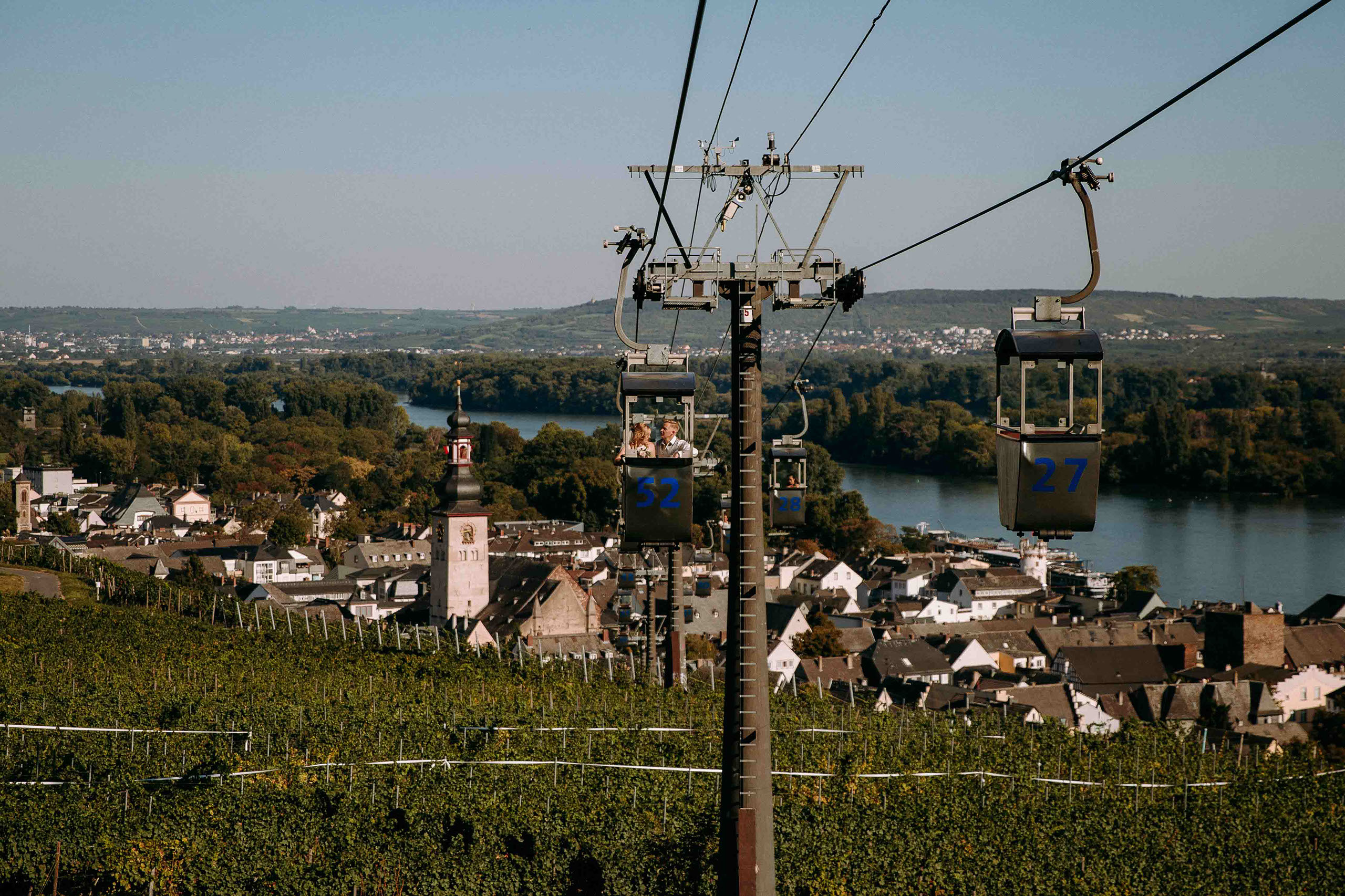 Braut und Bräutigam fahren in der Seilbahn über Rüdesheim – romantischer Moment im Rheingau.
