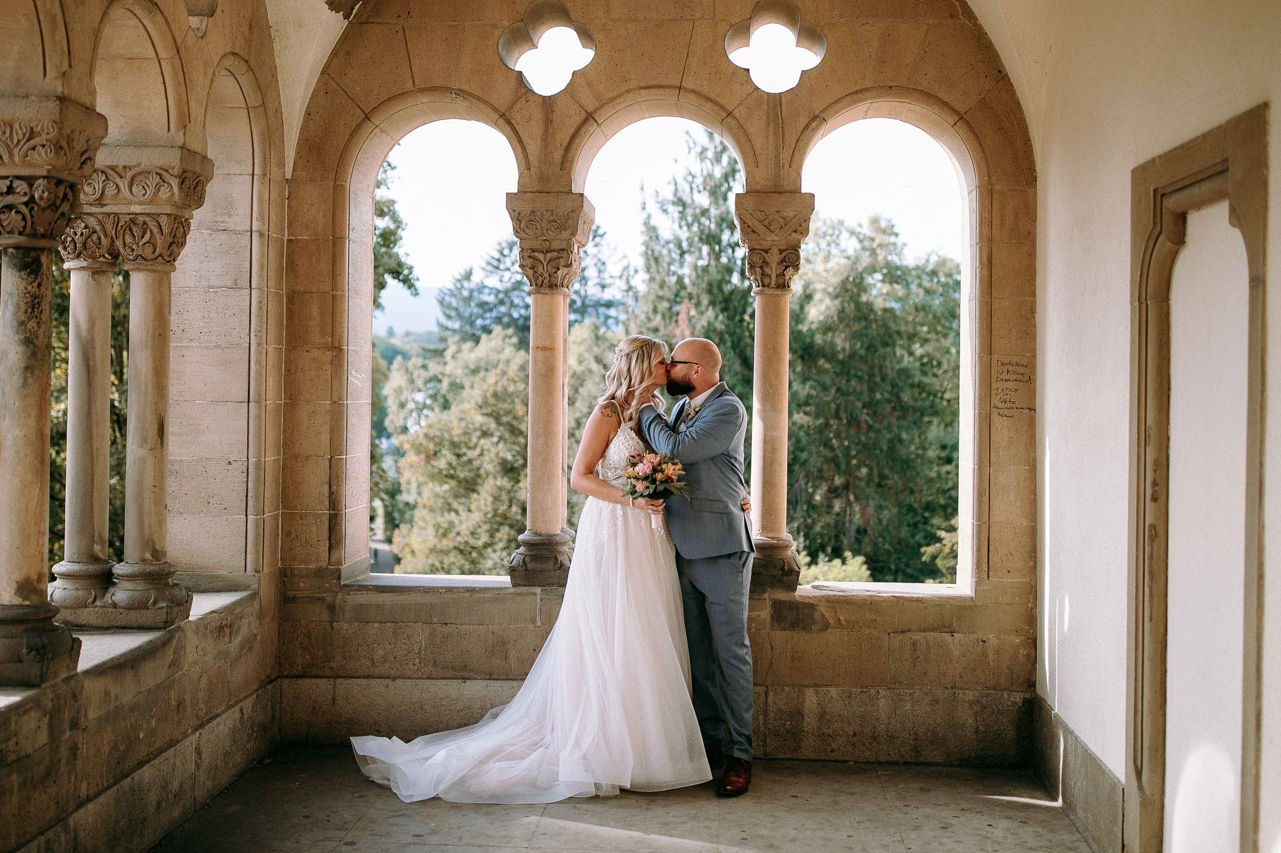 Romantischer Kuss im Säulengang – Hochzeitslocation Schloss Bad Homburg