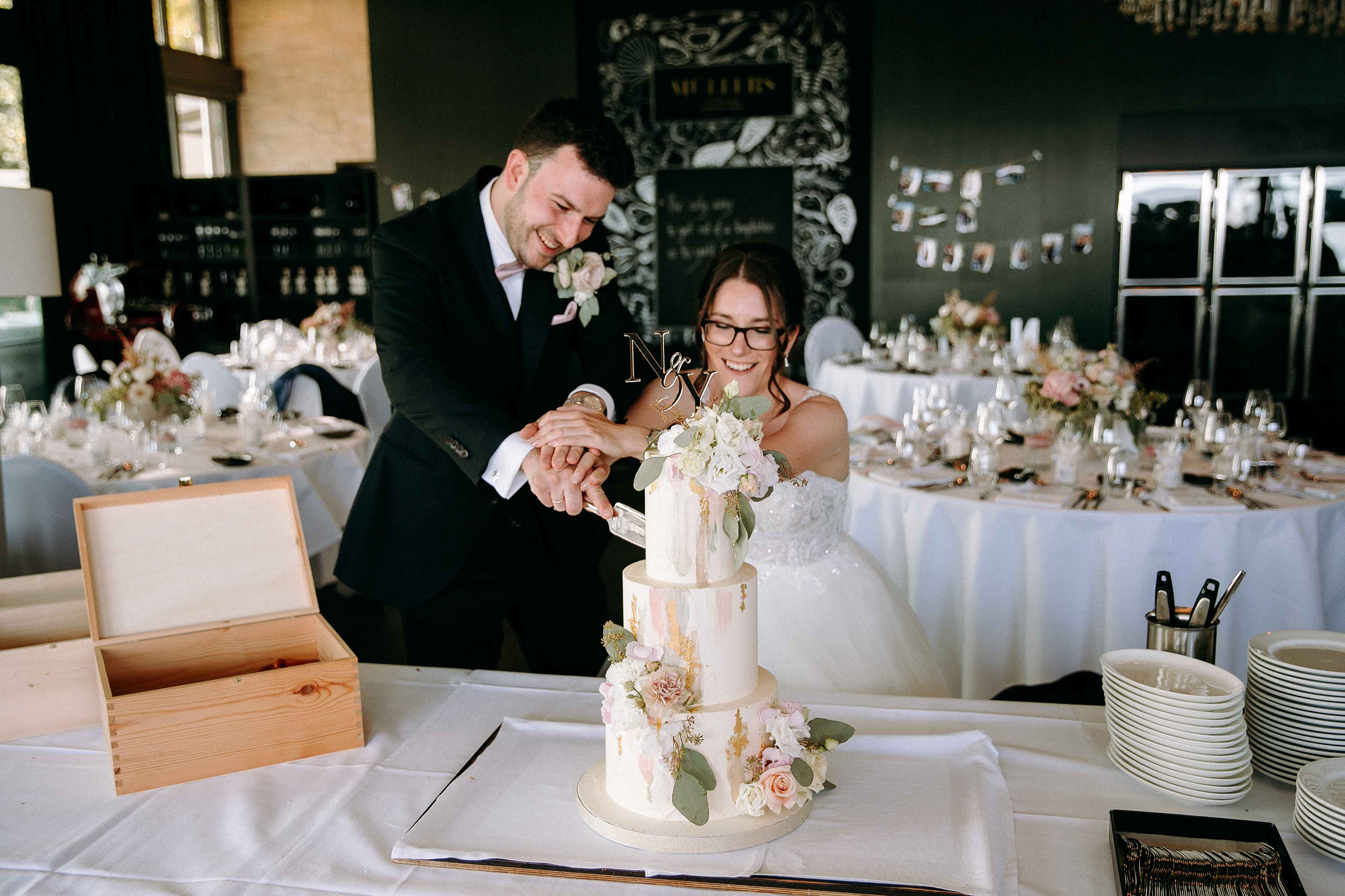 Braut und Bräutigam schneiden die dreistöckige Hochzeitstorte in der Hochzeitslocation Burg Schwarzenstein an – Hochzeitsfotos Rheingau.