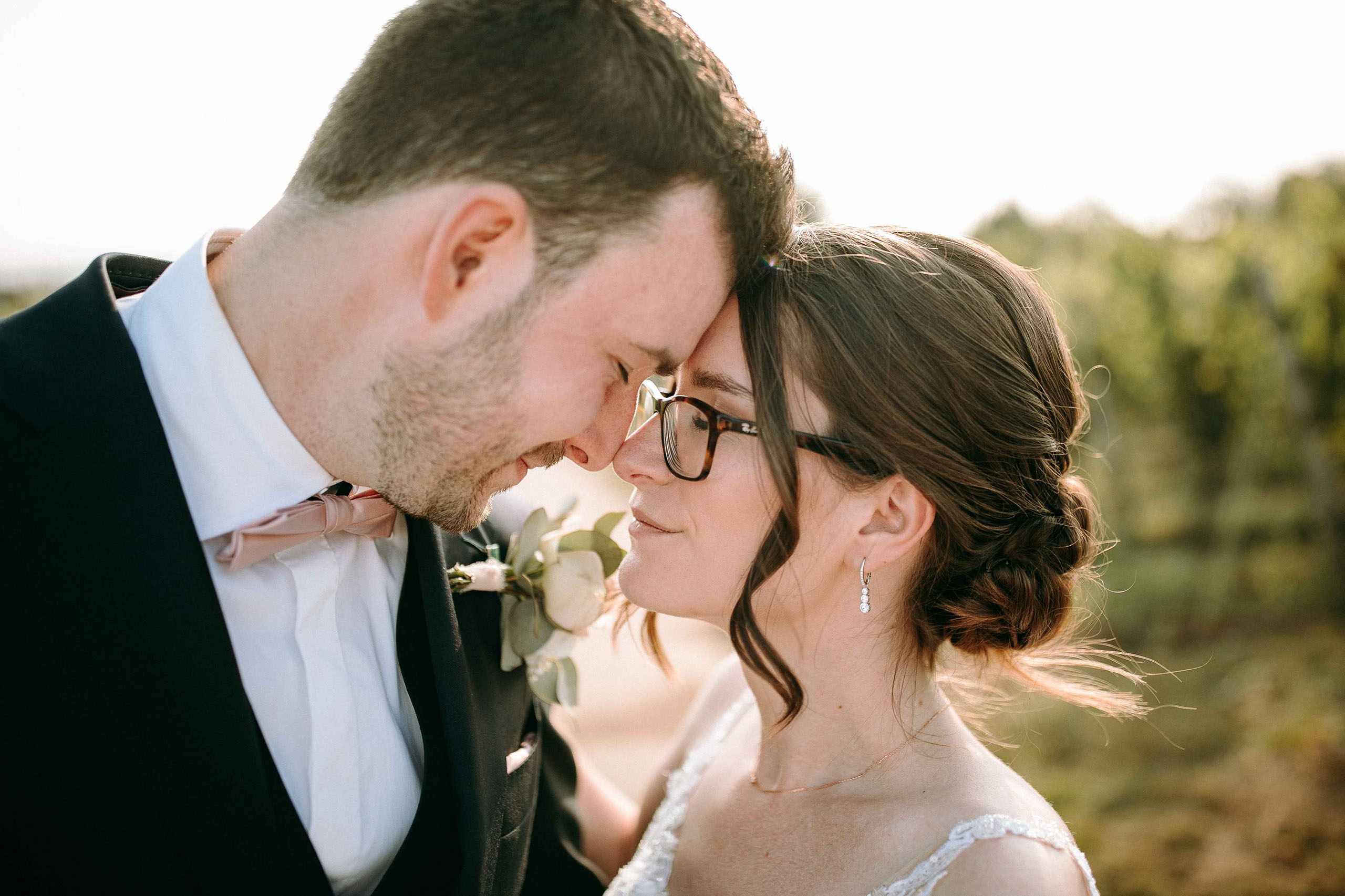 Inniger Blickkontakt des Brautpaars mit Stirn an Stirn bei Sonnenlicht in der Hochzeitslocation Burg Schwarzenstein – Hochzeitsfotos Rheingau.