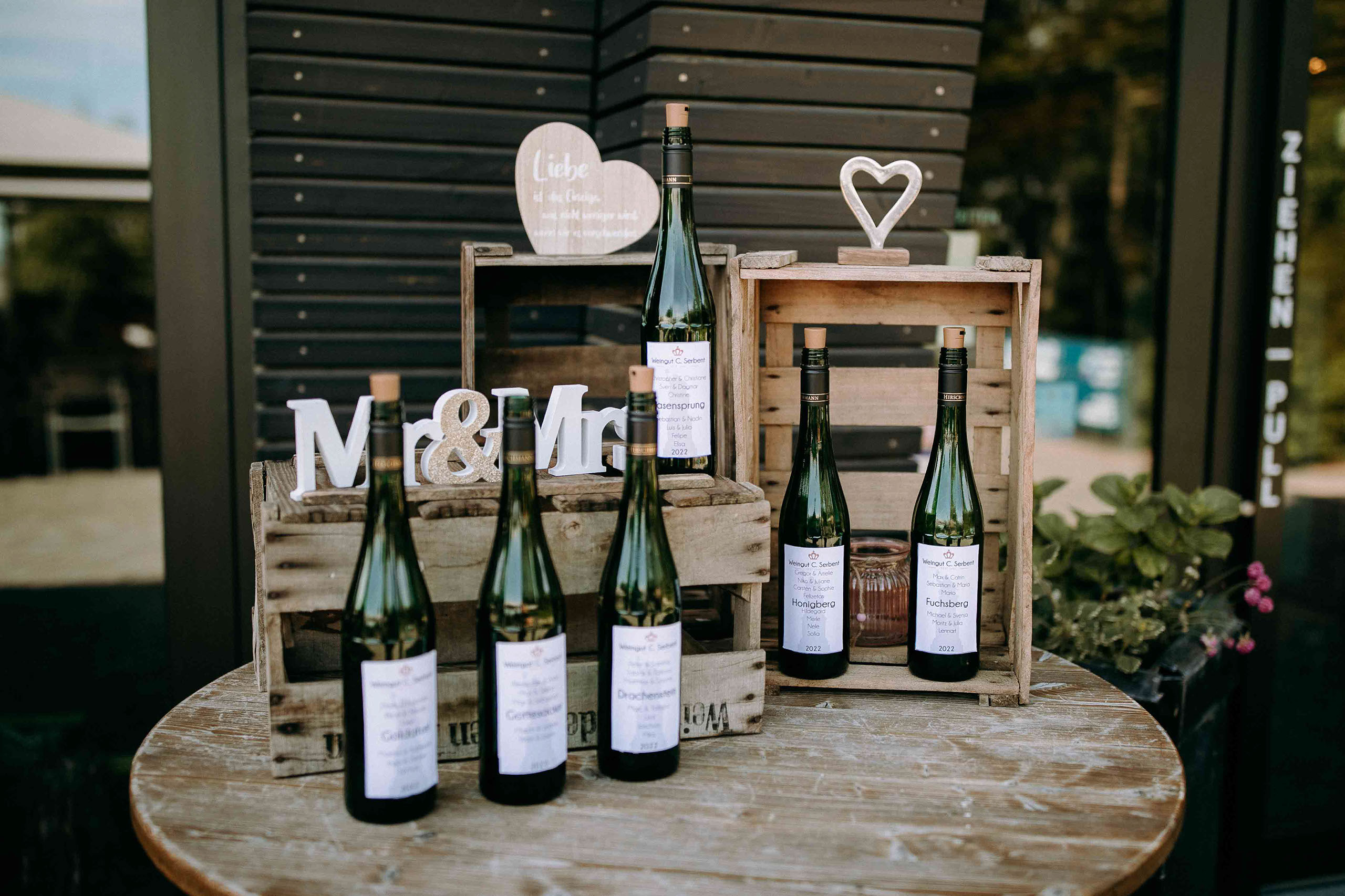 Weinflaschen und rustikale Deko mit Mr & Mrs Schild – Hochzeitslocation Am Niederwald im Rheingau.