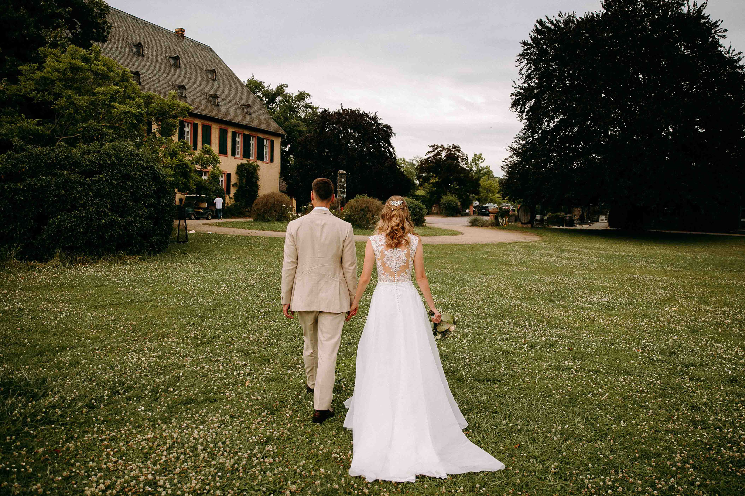 Brautpaar auf dem Weg zum Gutshaus – Draiser Hof als romantische Hochzeitslocation Baron Knyphausen im Rheingau.
