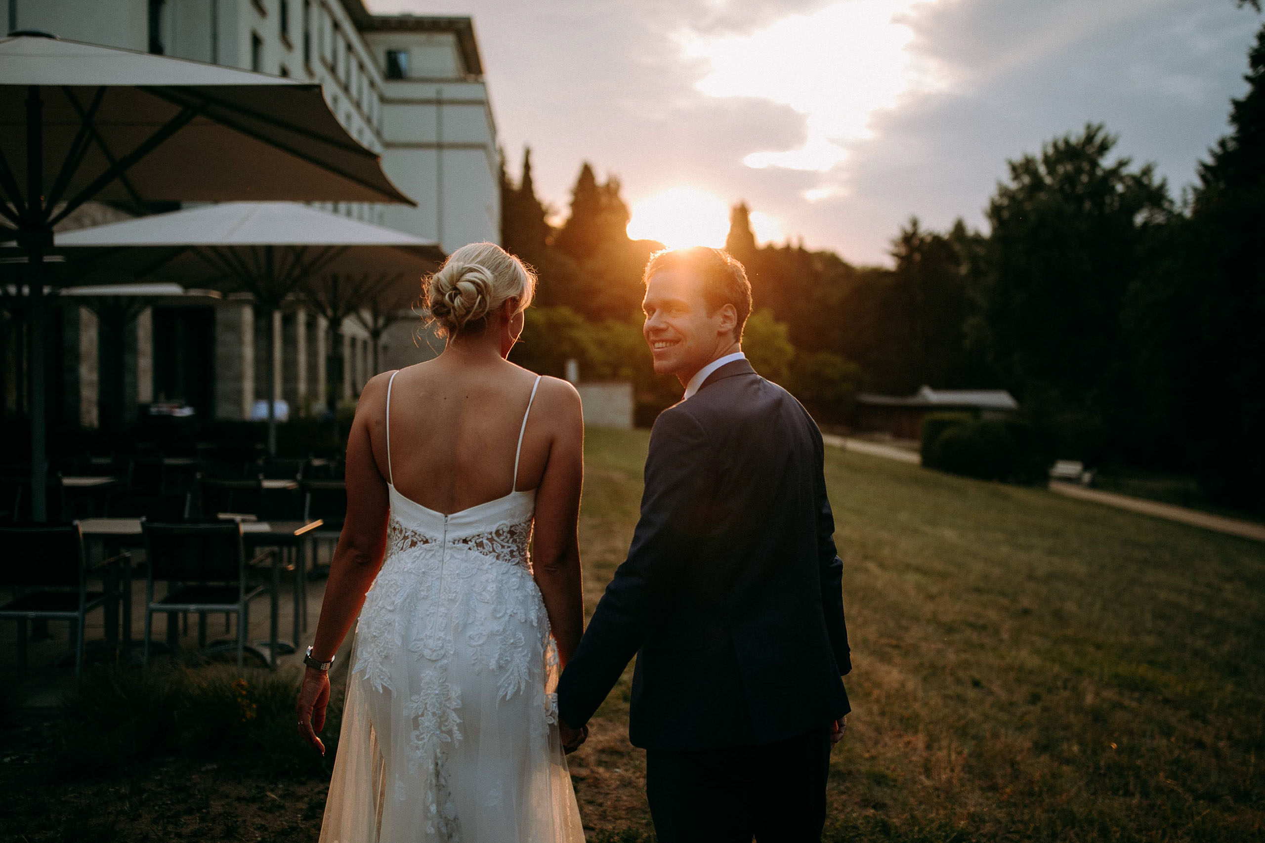 Brautpaar Hand in Hand bei Sonnenuntergang vor dem Dorint Hotel Oberursel – Hochzeitsfotograf in Aktion.