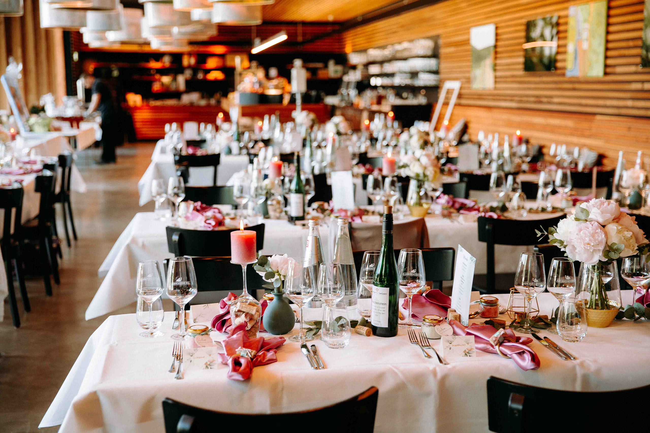 Hochzeitstische mit floralen Arrangements und Kerzenlicht bei der Hochzeitslocation Am Niederwald im Rheingau