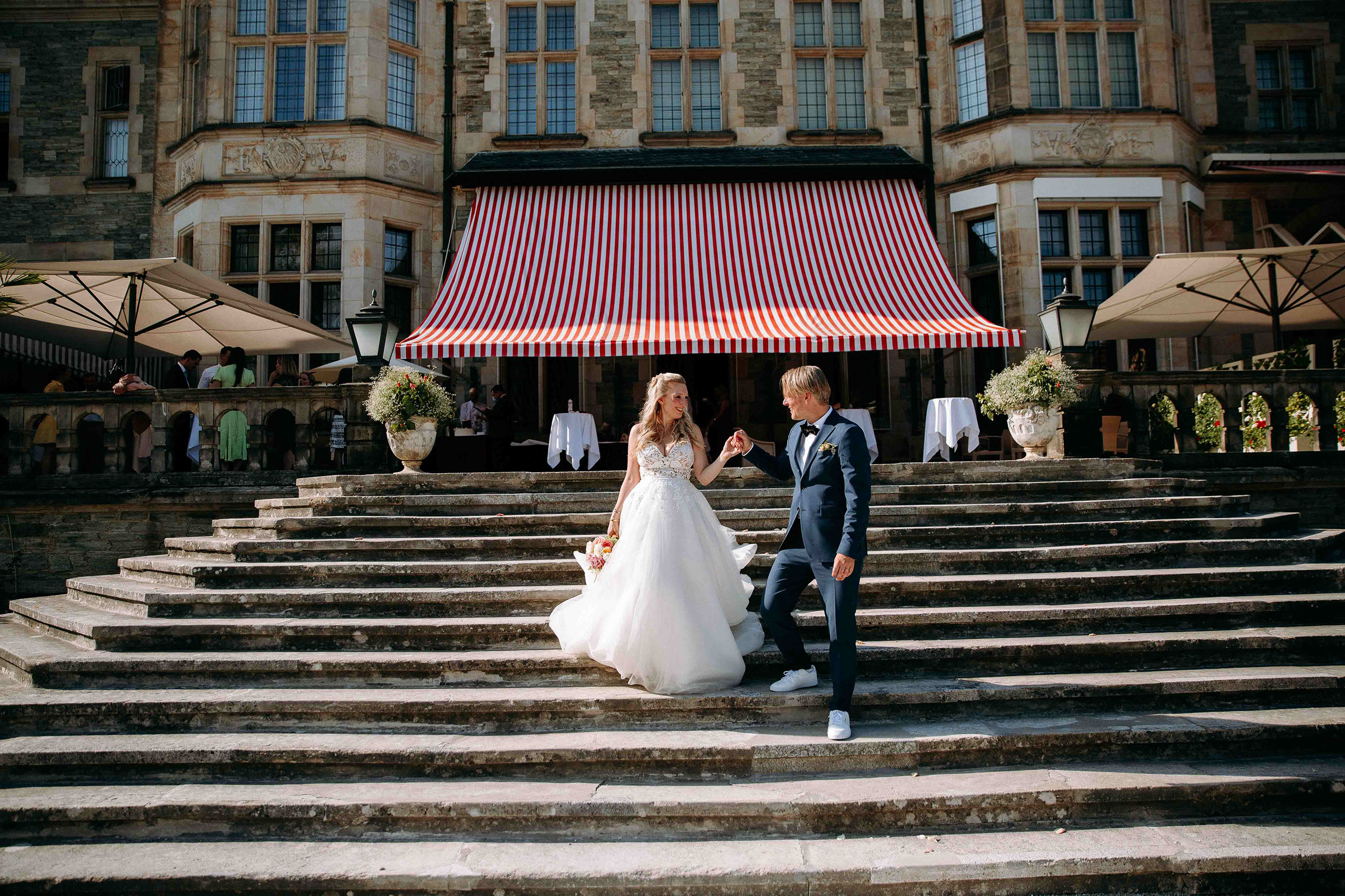 Braut und Bräutigam auf der Treppe des Schlosshotel Kronberg – elegante Hochzeitslocation