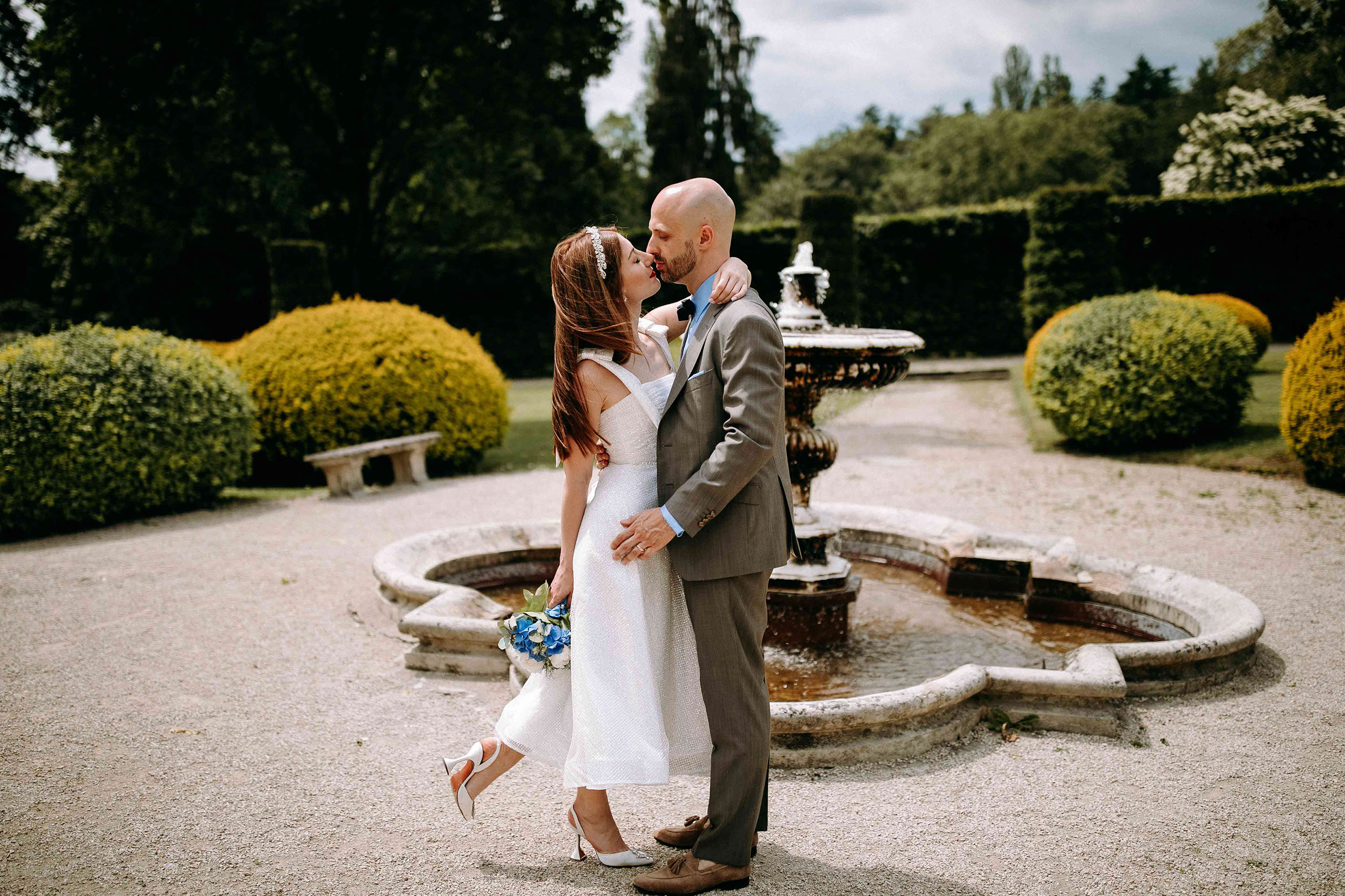 Romantischer Kuss des Brautpaares am Brunnen des Schlosshotel Kronberg – beliebte Hochzeitslocation