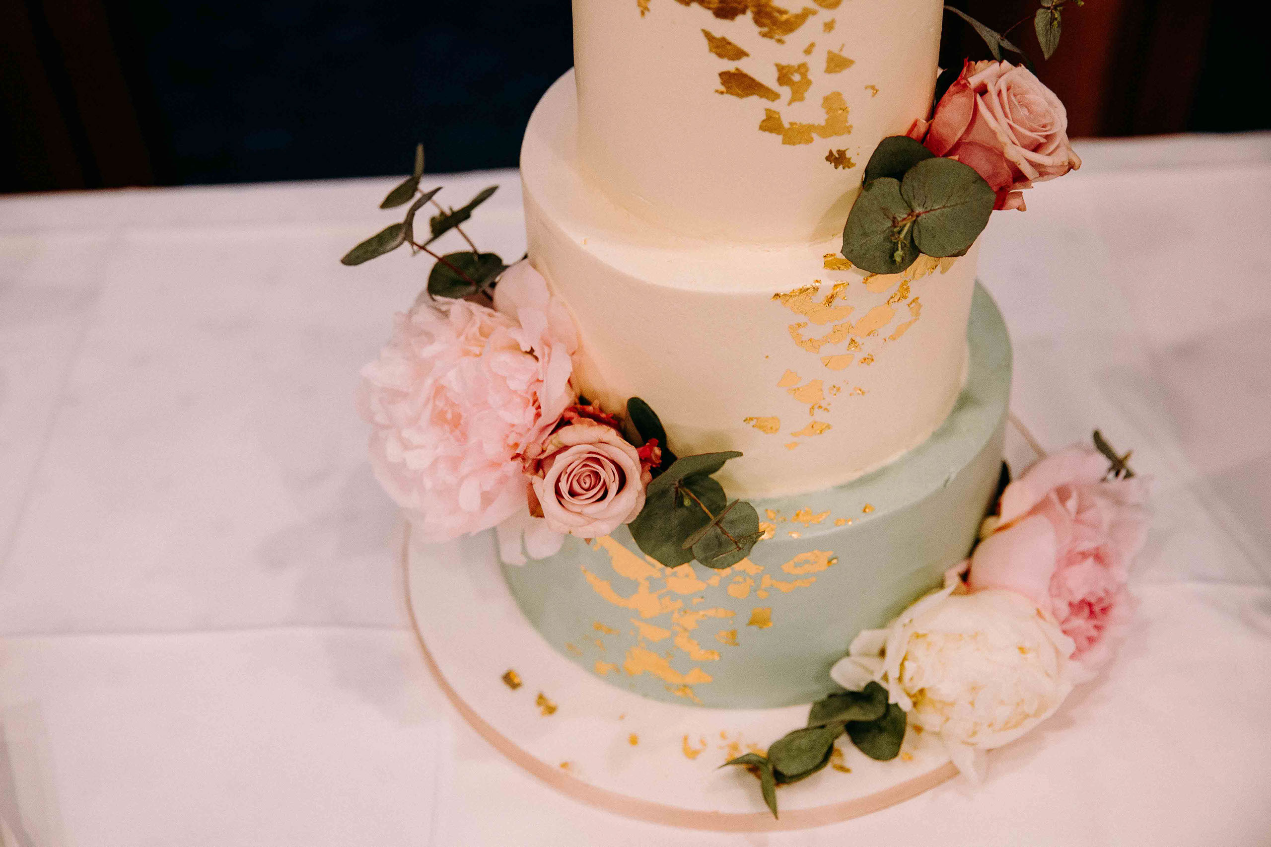 Detailansicht der Hochzeitstorte mit rosa Rosen und goldenen Akzenten – Hochzeitslocation Am Niederwald im Rheingau.