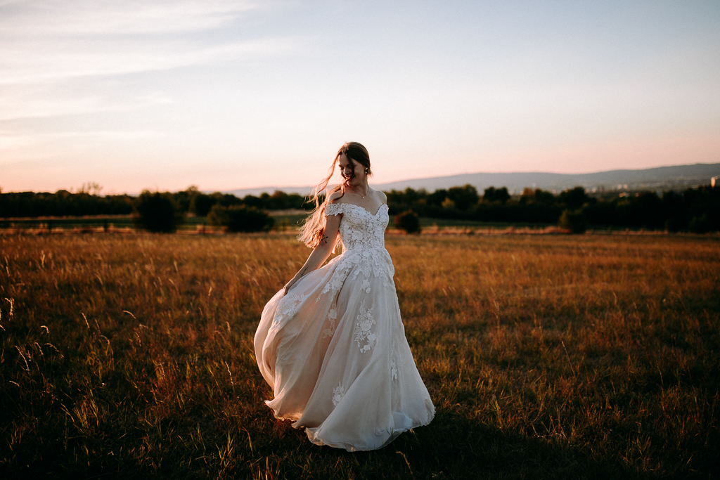 Das Brautpaar steht vor dem offenen Fenster und schaut sich an.