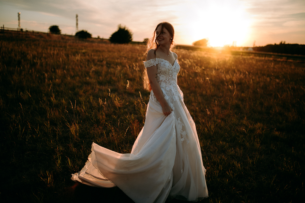Das Brautpaar steht vor dem offenen Fenster und schaut sich an.