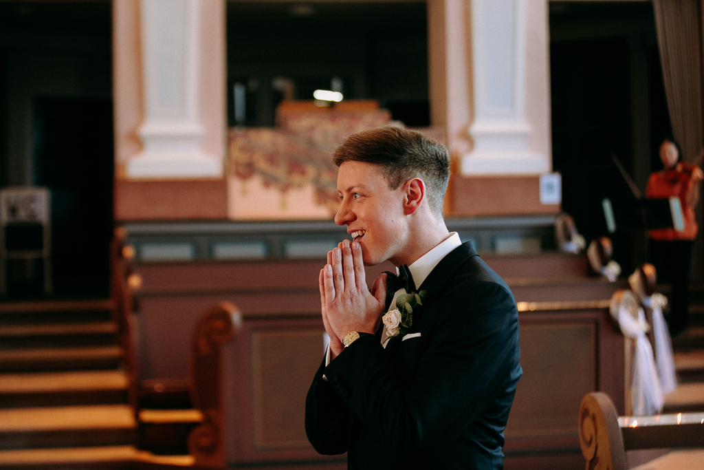 Das Brautpaar sieht sich verliebt im Kaiserdom am Altar an.
