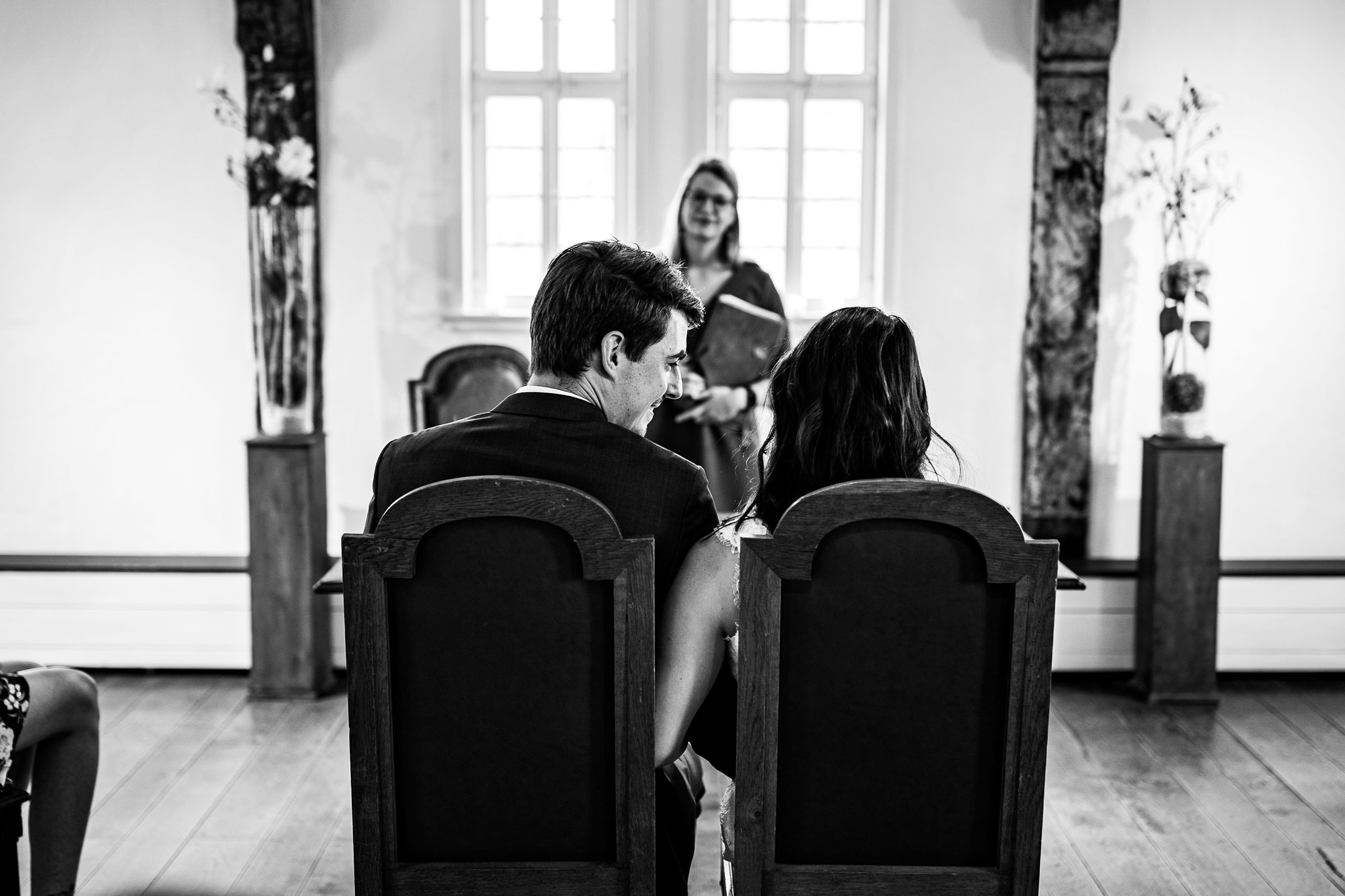 Der Bräutigam schaut die Braut bei der standesamtlichen Trauung glücklich an. 