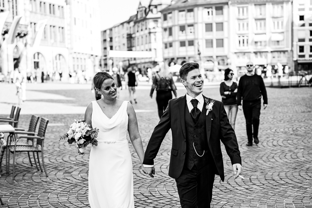 Das Brautpaar läuft glücklich über den Römer nach ihrer standesamtlichen Trauung.