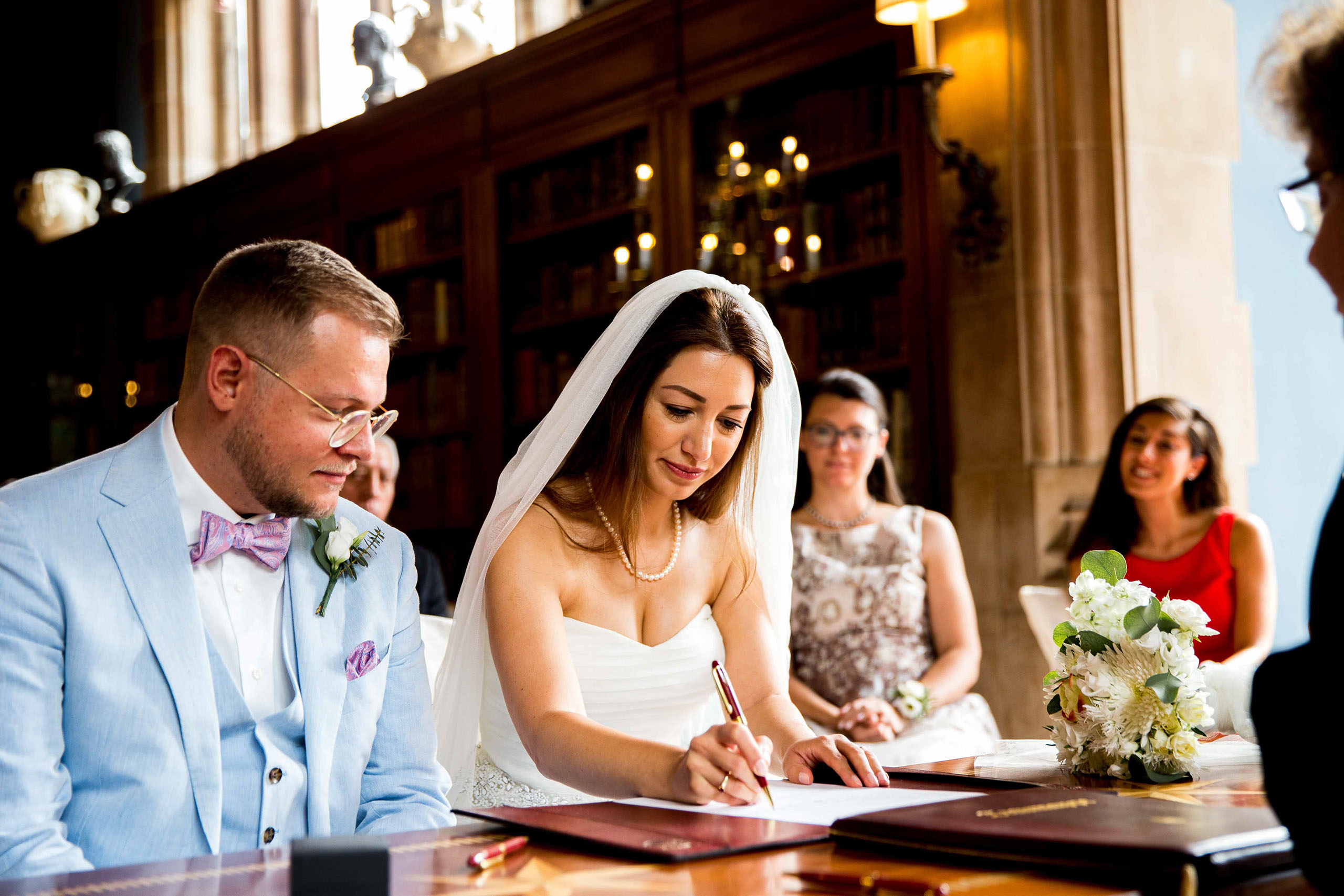 Unterschrift der Braut im Standesamt vom Schlosshotel Kronberg Das Brautpaar bei der Unterschrift im Standesamt Schlosshotel Kronberg in der Bibliothek.