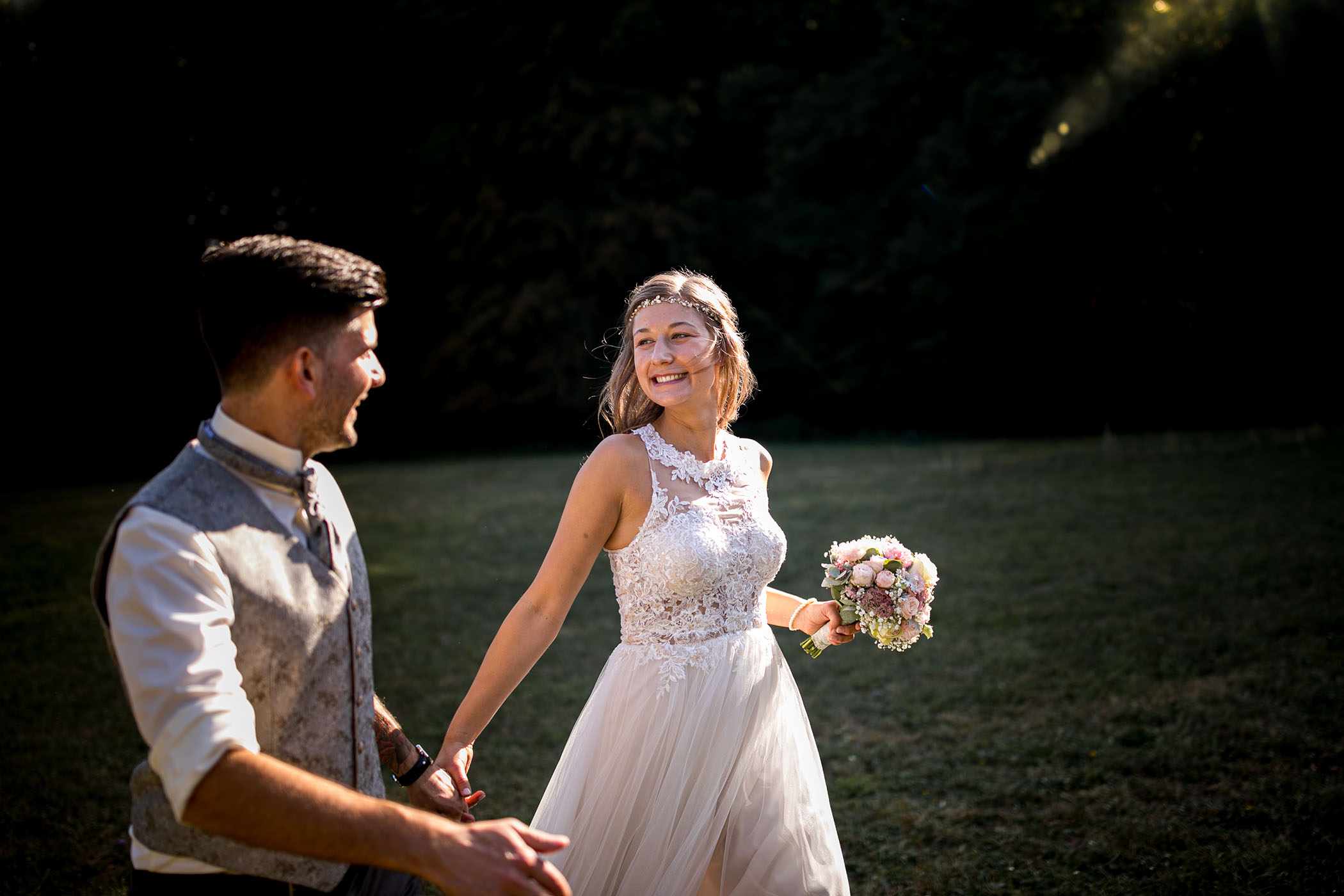 Das Brautpaar steht vor dem offenen Fenster und schaut sich an.